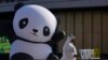 A person walks outside of the China Pavilion near an inflatable panda at the COP28 UN Climate Summit, Dec. 8, 2023, in Dubai, United Arab Emirates. 