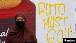A woman walks next to a graffiti done by protesters who were against the imposition of tax hikes by the government, in Nairobi, Kenya, July 4, 2024.