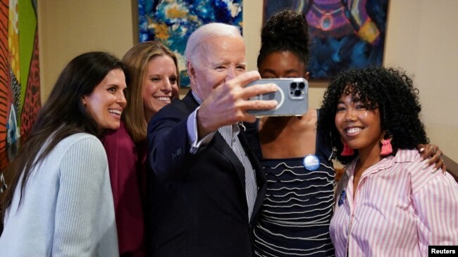 FILE - U.S. President Joe Biden poses for a selfie in Hannibal's Kitchen restaurant during his visit in Charleston, South Carolina, while campaigning for reelection, Jan. 8, 2024.