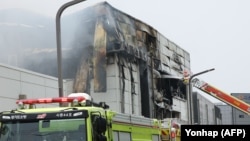 Firefighters work to extinguish a fire at a lithium battery factory in Hwaseong, South Korea, June 24, 2024. 