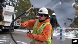 A worker from Portland General Electric replaces a power line as crews work to restore power after a storm on Jan. 16, 2024, in Lake Oswego, Oregon, Feb. 2, 2024, the U.S. government issues its January jobs report. 