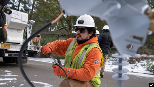 A worker from Portland General Electric replaces a power line as crews work to restore power after a storm on Jan. 16, 2024, in Lake Oswego, Oregon, Feb. 2, 2024, the U.S. government issues its January jobs report.