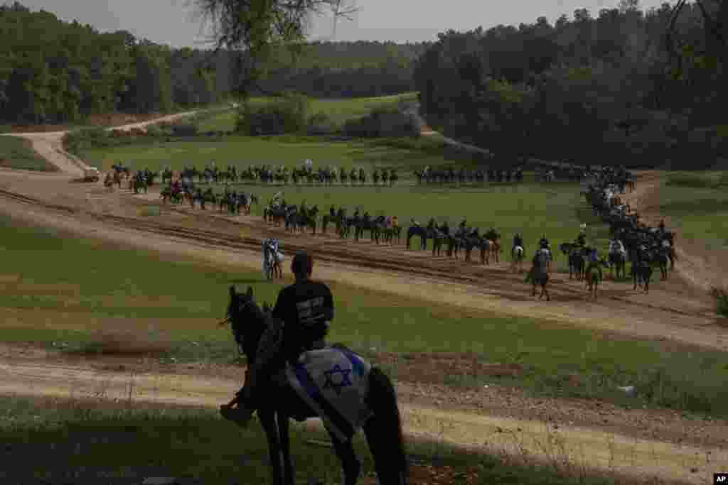 Family and supporters of Israeli hostages held by Hamas in Gaza gather for a horse ride calling for their return, in a forest near Modiin.