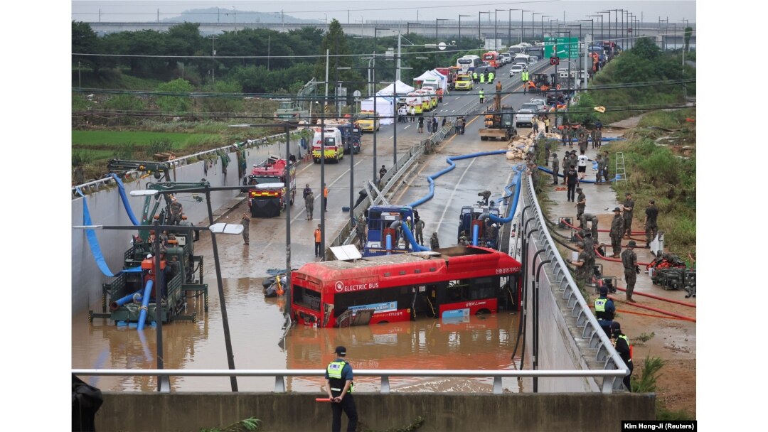 Petugas penyelamat terlihat di dekat bus listrik yang ditemukan selama operasi pencarian dan penyelamatan di dekat jalan bawah tanah yang terendam banjir akibat hujan deras di Cheongju, Korea Selatan, 16 Juli 2023. (Foto: REUTERS/Kim Hong-ji )