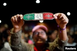 Seorang pria mengangkat gelang dalam konferensi pers terakhir Interdisipliner Group of Independent Experts (GIEI) tentang 43 siswa Sekolah Pelatihan Guru Ayotzinapa yang hilang, di Mexico City, Meksiko 25 Juli 2023. (REUTERS/Raquel Cunha)