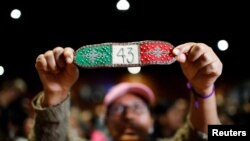 A person holds up a bracelet during the Interdisciplinary Group of Independent Experts' press conference on the 43 missing students of the Ayotzinapa Teacher Training College, in Mexico City, Mexico, July 25, 2023.