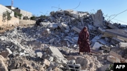 Ibu Ahmed Dawabsha berjalan di atas reruntuhan rumahnya di desa Duma di Tepi Barat yang diduduki Israel, 3 Juli 2024, setelah rumah tersebut dihancurkan oleh tentara Israel yang menangkap putranya pada bulan April atas pembunuhan seorang remaja Israel. (Zain JAAFAR/AFP)
