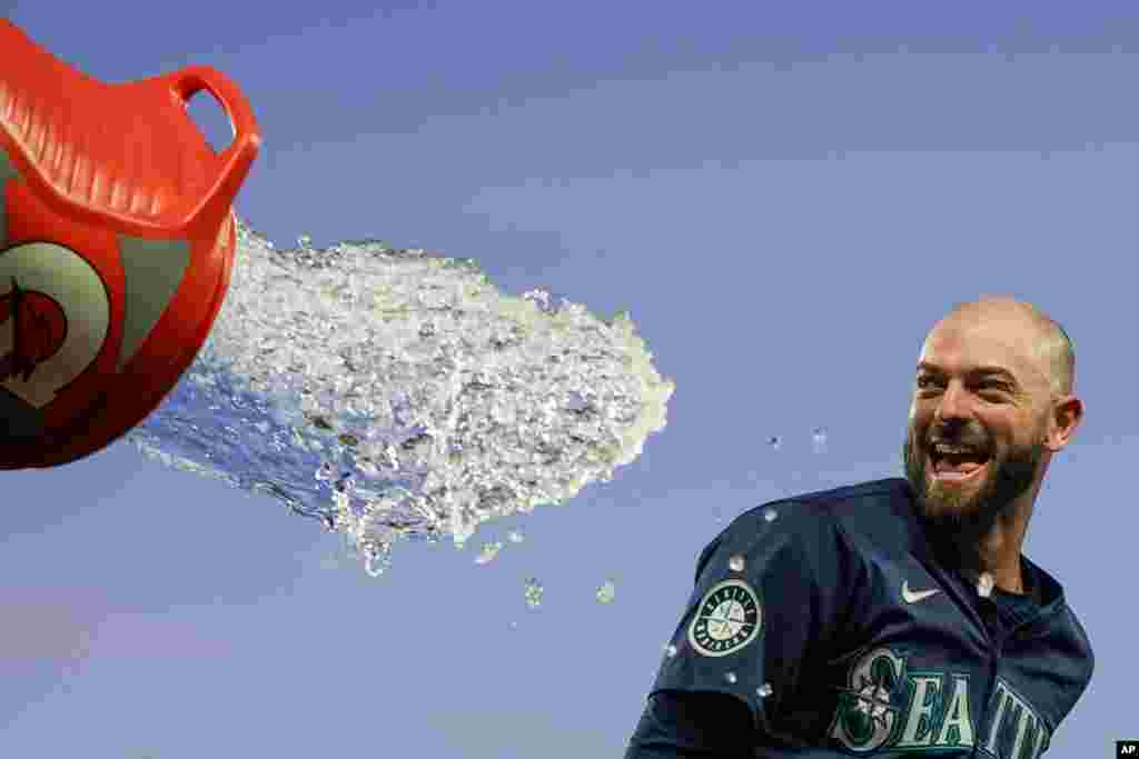 Seattle Mariners&#39; Mitch Haniger tries to avoid a dousing during the celebration of the team&#39;s 2-1 win over the Chicago White Sox in 10 innings in a baseball game, June 12, 2024, in Seattle. Haniger drove in the winning run. (AP Photo/Lindsey Wasson)