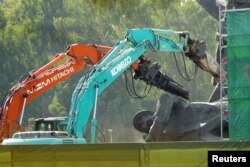 FILE - A sculpture depicting a Soviet army soldier is knocked down during dismantling of a Soviet World War Two victory monument in Riga, Latvia, Aug. 23, 2022.