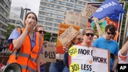 FILE- Members of the Unite union stand on the picket line outside Guys and St Thomas' Hospital during a 24 hour strike in a dispute over pay, in London, July 13, 2023.