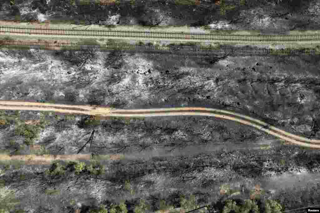 An aerial view shows railroad tracks running through an area burned by a wildfire, near Volos, Greece.