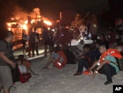 In this photo provided by the Philippine Coast Guard, survivors rest after being rescued from the still burning MV Lady Mary Joy 3 at Basilan, southern Philippines, March 30, 2023.