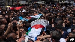 Palestinian mourners carry the bodies of Hamza Maqbool, 32, rear and Khayri Shaheen, 34, during their funeral in the West Bank city of Nablus, July 7, 2023.