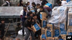 FILE - Palestinians loot a humanitarian aid truck as it crossed into the Gaza Strip in Rafah, Dec. 17, 2023.