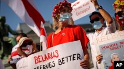 FILE - People shout slogans during a small protest against Belarusian President Alexander Lukashenko outside the European Parliament in Brussels, on Sept. 15, 2020.