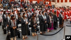 FILE - In this photo provided by Navajo Technical University, students at the school stand during a graduation ceremony, in Crownpoint, New Mexico, Dec. 16, 2022. 