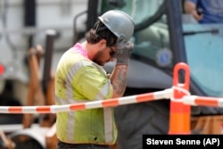 FILE - A man works on a gas line in temperatures above 90 degrees, June 20, 2024, Boston. (AP Photo/Steven Senne)