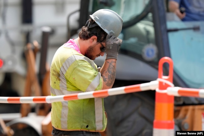 FILE - A man works on a gas line in temperatures above 90 degrees, June 20, 2024, Boston. (AP Photo/Steven Senne)