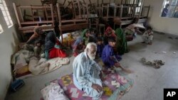 Beberapa keluarga berlindung di sebuah sekolah setelah mengungsi dari desa mereka di daerah pesisir untuk menghindari ancaman badai Biparjoy yang mendekat, di Gharo dekat kota Thatta, Pakistan, Rabu 14 Juni 2023.