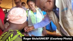 UNICEF representative in Malawi Shadrack Omol gives a polio vaccine to a child in the Chiradzulu district of Malawi, Sept. 12, 2023.