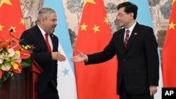 হন্ডুরাসের পররাষ্ট্রমন্ত্রী এডুয়ার্ডো এনরিকে রেইনা গার্সিয়া ও চীনের পররাষ্ট্রমন্ত্রী কিন গ্যাং ২ দেশের মধ্যে কূটনৈতিক সম্পর্ক স্থাপনের পর হাত মেলাচ্ছেন; ২৬ মার্চ, ২০২৩।