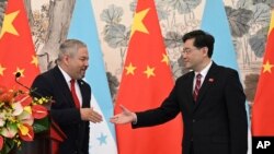 Honduras Foreign Minister Eduardo Enrique Reina Garcia and Chinese Foreign Minister Qin Gang shake hands following the establishment of diplomatic relations between the two countries, in the Diaoyutai State Guesthouse in Beijing, March 26, 2023. 