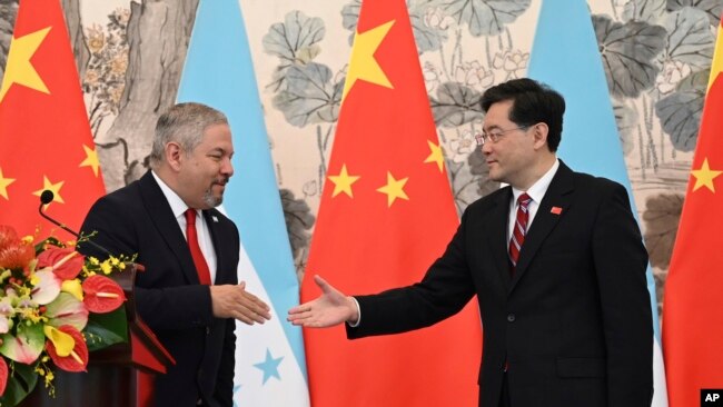 Honduras Foreign Minister Eduardo Enrique Reina Garcia and Chinese Foreign Minister Qin Gang shake hands following the establishment of diplomatic relations between the two countries, in the Diaoyutai State Guesthouse in Beijing, March 26, 2023.