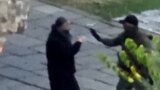 Naoružani čovjek razgovara sa sveštenikom u manastiru Banjska.