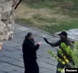 Naoružani čovek razgovara sa sveštenikom u manastiru Banjska (Foto: Reuters/Kosovo Government/Handout)