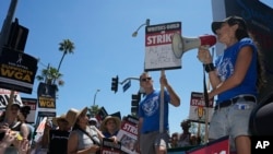 FILE - Actor and filmmaker Justine Bateman, right, speaks outside Netflix during a Writers Guild rally on July 13, 2023, in Los Angeles.