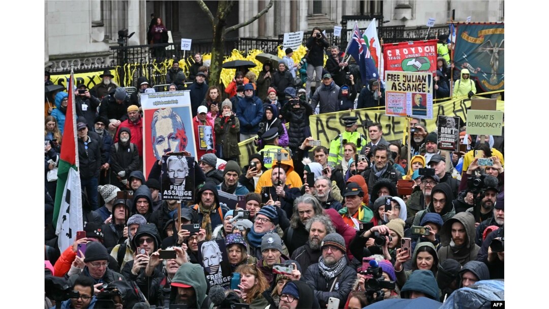 Supporters of WikiLeaks founder Julian Assange listen as his wife Stella Assange (unseen) makes a speech outside The Royal Courts of Justice, Britain's High Court, in central London, Feb. 21, 2024,