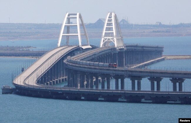A train moves along the Crimean Bridge, a section of which was damaged by an alleged overnight attack, as seen from the city of Kerch, Crimea, July 17, 2023.