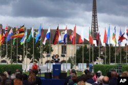 Ibu Negara Jill Biden (kiri), mendengarkan pidato Direktur Jenderal Unesco Audrey Azoulay pada upacara pengibaran bendera AS di kantor pusat UNESCO di Paris, Selasa, 25 Juli 2023. (AP/Aurelien Morissard, Pool)