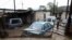 Cars are seen partially submerged in flood waters in front of a house following heavy rains, in Sir Lowry's Pass Village, Western Cape, South Africa, Sept. 25, 2023.