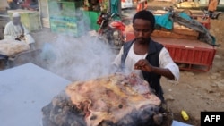 FILE - A chef prepares a traditional dish of the Beja tribes at an open air cafe in Port Sudan, the capital of the Red Sea state in eastern Sudan, on Nov.14, 2023. U.N. food agencies warn of a coming hunger catastrophe in 2024 in the warring nation.