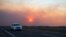 A car rides on the road to Roswell, New Mexico, as smoke from a wildfire partially blocks the sun near the village of Ruidoso, June 18, 2024.