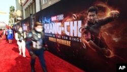 Para penggemar mengenakan kostum karakter-karakter Marvel saat menghadiri pemutaran perdana "Shang-Chi and the Legend of the Ten Rings" di Teater El Capitan, Los Angeles, Senin, 8 Agustus. 16, 2021. (Jordan Strauss/Invision/AP)