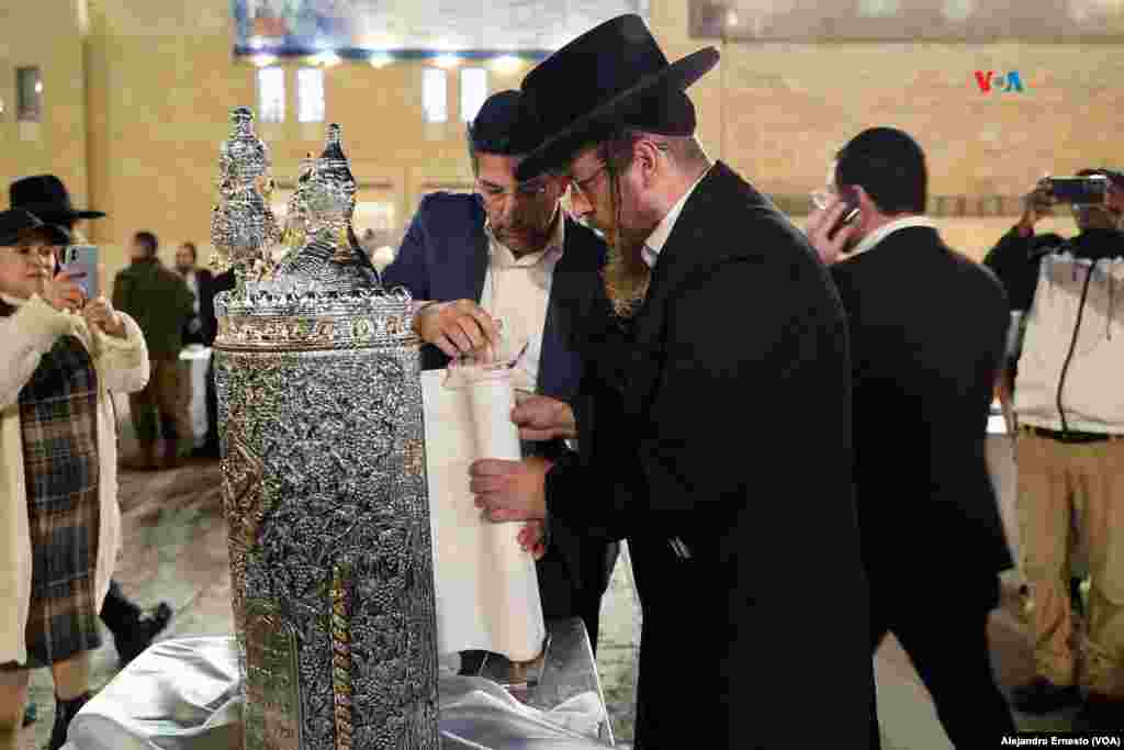 Dos hombres guardan los rollos de la Torá durante una ceremonia por los secuestrados en poder de Hamás y por los israelíes caídos durante la guerra.