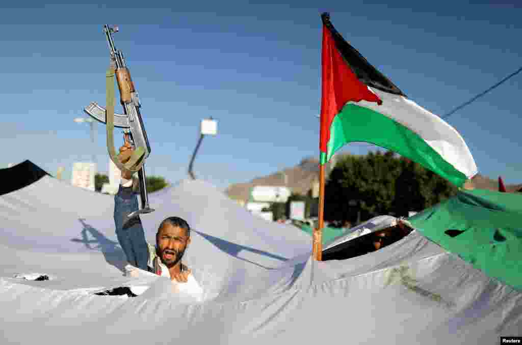 A protester holds a gun, as he takes part in a demonstration in solidarity with Palestinians in the Gaza Strip, amid the ongoing conflict between Israel and the Palestinian Islamist group Hamas, in Sanaa, Yemen.