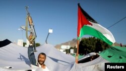 A protester holds a gun, as he takes part in a demonstration in solidarity with Palestinians in the Gaza Strip, amid the ongoing conflict between Israel and the Palestinian Islamist group Hamas, in Sanaa, Yemen.
