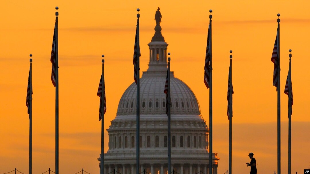 Foto Achiv: Yon pyeton mache sou plas nasyonal la ak silouwet Capitol la deye li, 7 Nov. 2022. 