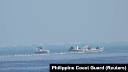 菲律宾海岸警卫队2023年9月24日发布的拍摄于9月20日的照片显示，中国海警船在南中国海斯卡伯勒浅滩附近的浮标屏障旁。
