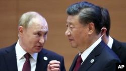 資料照片：2022年9月16日，俄羅斯總統普京在烏茲別克斯坦撒馬爾罕舉行的上海合作組織峰會上與中國國家主席習近平交談時做手勢。 （美聯社照片）