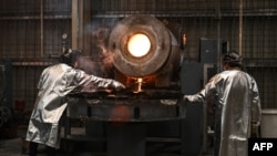 A worker takes a sample for testing as molten gold is poured into bars at the Akara Resources' Chatree gold mine in Thailand's Phichit province, March 23, 2023.