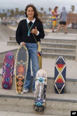 Di'Orr Greenwood, whose work is featured on the new US stamps, poses for a picture with her painted skateboards in the Venice Beach neighborhood in Los Angeles, March 20, 2023.