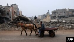 A man rides a horse-pulled cart along a street ravaged by Israeli bombing in Rafah in the southern Gaza Strip on Feb. 9, 2024.