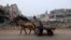 A man rides a horse-pulled cart along a street ravaged by Israeli bombing in Rafah in the southern Gaza Strip on Feb. 9, 2024.