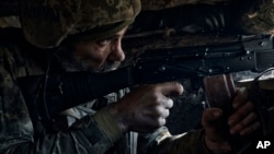 A Ukrainian soldier of the 28th Brigade fires during a battle with Russian troops at the front line near Bakhmut, Donetsk region, Ukraine, March 24, 2023.