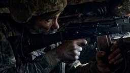 A Ukrainian soldier of the 28th Brigade fires during a battle with Russian troops at the front line near Bakhmut, Donetsk region, Ukraine, March 24, 2023.