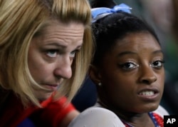 Simone Biles speaks with coach Aimee Boorman during the artistic gymnastics women's individual all-around final at the 2016 Summer Olympics in Rio de Janeiro, Brazil, Aug. 11, 2016.